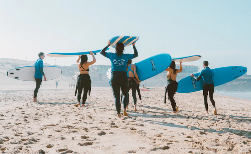 Surfers at sunset beach camp with surfboards